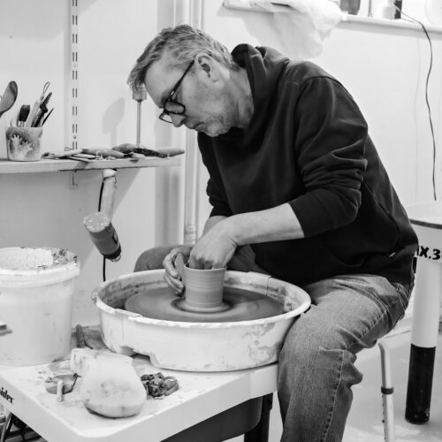 Black and white photo of a man working at a potter's wheel